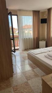a bedroom with a bed and a view of a balcony at Stoyko's Guest House in Pomorie