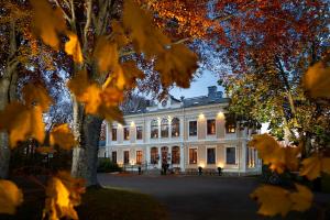 a large white building with lights on it at Karstorp Säteri – Hotell och Konferens in Skövde