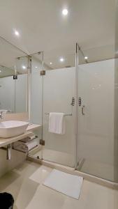 a bathroom with a shower and a sink at Pride Premier Bengaluru in Bangalore +36 photos