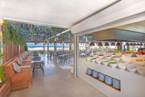 a restaurant with tables and chairs and food on display at Oz Hotels Side Premium in Side