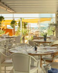 a restaurant with tables and chairs with a view of the ocean at Hotel Globus Pool & Beach in Milano Marittima