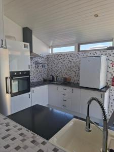 a kitchen with white appliances and a sink at Casa de la Serenidad in Mazarrón