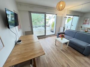 a living room with a couch and a table at Le Cocon Baulois in La Baule