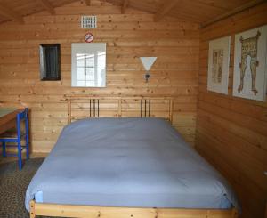 a bedroom with a bed in a log cabin at Countryside Eco Natuurhuisjes in Ee