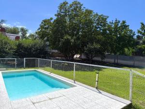 a swimming pool with a fence around it at Casa hasta 10 personas. in Villa Rumipal