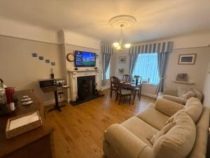 a living room with a couch and a table at Holly Trees Guest Accommodation in Seahouses