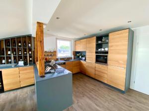 a large kitchen with wooden cabinets and a counter at Villa Iduna mit modern desingten Apartments in Graal-Müritz