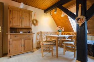 a dining room with a wooden table and chairs at Ferienwohnung Hertel in Mistelgau