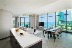 a kitchen and living room with a table and chairs at Charthouse Bahrain in Manama