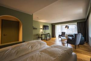 a bedroom with a bed and a living room at Hotel Lamm Baiersbronn Mitteltal in Baiersbronn +74 photos