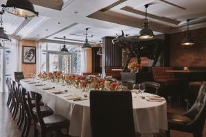 a long dining room with a long table with flowers at Fermain Valley Hotel in St. Peter Port