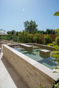 a pool in a backyard with benches and an umbrella at Mas de l'Etoile in Aureille