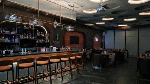 a bar in a restaurant with chairs and a counter at Pride Premier Bengaluru in Bangalore