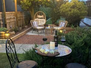 a patio with a table and chairs and wine glasses at Holly Trees Guest Accommodation in Seahouses