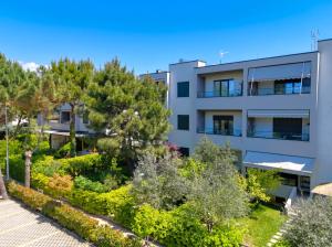 an apartment building with a garden in front of it at Wide Beach Apartments 236 in Mullini i Danit