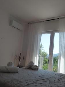 a bedroom with a bed and a large window at Apartman Ika 2 in Kruševo