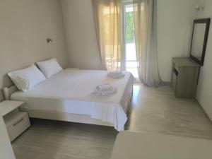 a white bed in a room with a window at Alexandros and Georgia in Ipsos