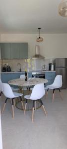 a kitchen with a table and white chairs in it at Apartman Ika 2 in Kruševo