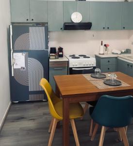 a kitchen with a table and a refrigerator at Nàra house 2 in Artemida