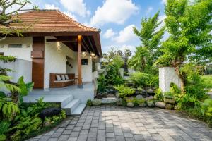 a garden with a bench and a house at Akar Villa in Ubud