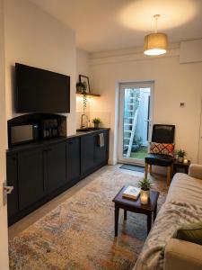 a living room with a flat screen tv and a couch at Planet 9 in Warrington