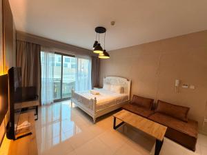 a bedroom with a bed and a couch and a tv at Aesthetic Kings Studio at Uptown Al Zahia Sharjah in Sharjah