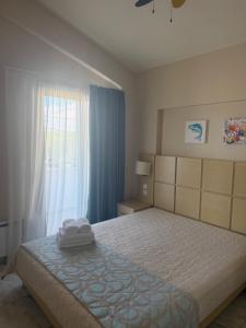 a bedroom with a large bed and a window at Amphipolis Deluxe Apartments in Ofrínion +39 photos
