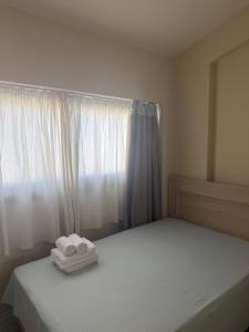 a bedroom with a bed with two towels on it at Amphipolis Deluxe Apartments in Ofrínion