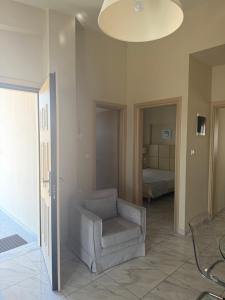 a living room with a chair and a bedroom at Amphipolis Deluxe Apartments in Ofrínion