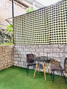 two chairs and a table in front of a brick wall at Regal Hotel in Kapan