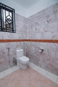 a bathroom with a white toilet in a room at Winsome Hotel Arusha in Themi +134 photos