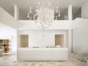 a white living room with a chandelier at Grecotel Casa Adele in Platanes