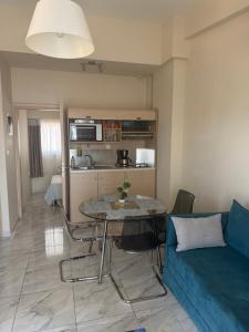 a living room with a blue couch and a table at Amphipolis Deluxe Apartments in Ofrínion