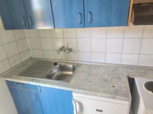 a kitchen counter with a sink and blue cabinets at Alexandros and Georgia in Ipsos