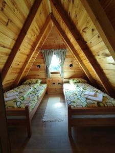 a attic bedroom with two beds in a log cabin at Durmitor Forest Retreat in Žabljak