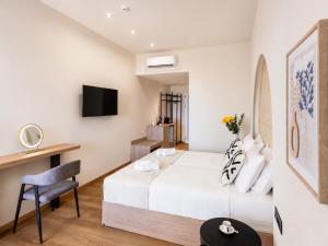 a bedroom with a bed and a desk and a surfboard at Venezia Sea Side Suites in Faliraki