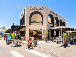 a store with tables and chairs and umbrellas at Venezia Sea Side Suites in Faliraki