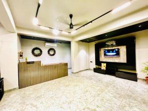 a lobby with a waiting room with a tv on the wall at Luxury Hotel Aura Residency in Rāiwāla