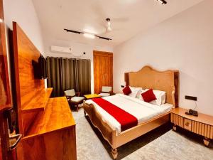 a hotel room with a bed and a desk and a room at Luxury Hotel Aura Residency in Rāiwāla