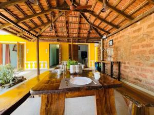 a dining room with a wooden table and yellow walls at Nina's Aqua - Private Pool Villa & Plunge Pool Studios, Anjuna in Anjuna