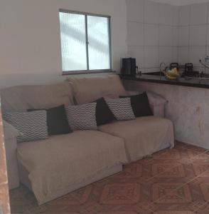 a brown couch with pillows on it in a kitchen at Casa completa com piscina 12min da praia in Porto Seguro +9 photos