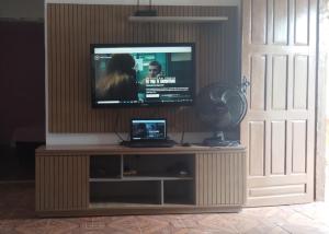 a flat screen tv sitting on top of a entertainment center at Casa completa com piscina 12min da praia in Porto Seguro