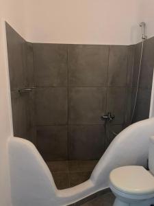 a bathroom with a tub and a toilet at Villa Viktoria in Elia beach, Mykonos in Mikonos