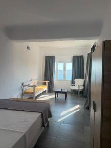 a bedroom with a bed and a living room at Villa Viktoria in Elia beach, Mykonos in Mikonos