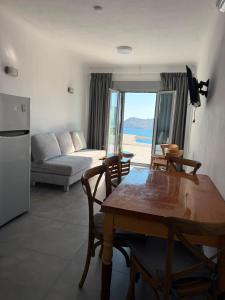 a living room with a table and chairs and a couch at Villa Viktoria in Elia beach, Mykonos in Mikonos