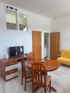 a living room with a table and chairs and a television at Tramontana apartments in Dugobabe