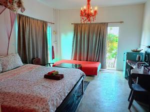 a bedroom with a bed and a chandelier at Six Nature Resort in Chiang Rai