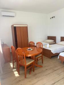 a room with a table and chairs and two beds at Tramontana apartments in Dugobabe