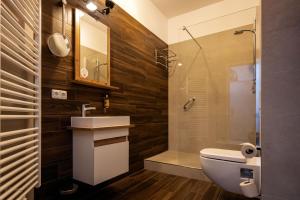 a bathroom with a toilet and a sink and a shower at Parkhotel Hohnstein by STEIGER Hotels in Hohnstein