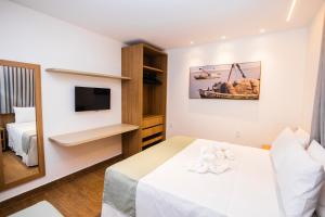 a hotel room with a bed and a tv at Landruá Flat in São Luís